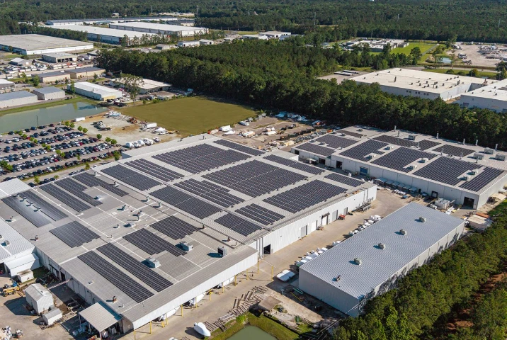 Aerial view of an industrial park with solar arrays on several warehouse roofs