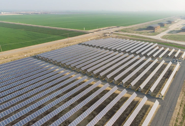 Rows of solar panels beside open farmland